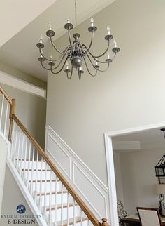 a chandelier hanging from the ceiling in a room with white walls and stairs