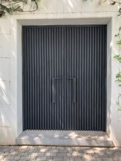 an open garage door in front of a white wall