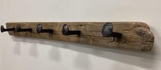 a coat rack made out of wood with five hooks hanging from it's sides