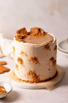 a cake with frosting and cinnamon sprinkles sitting on a white table