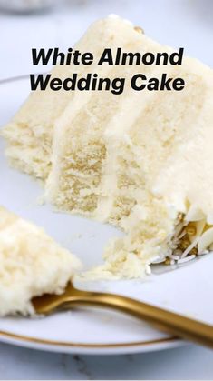 a piece of white cake on a plate with a gold fork and spoon next to it