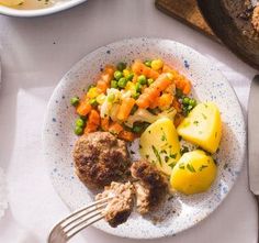 a plate with meatballs, potatoes and carrots on it