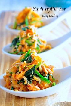 three white bowls filled with food on top of a wooden table