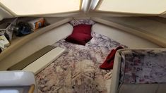 the inside of a small boat with a bed and pillows on it's side