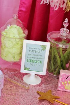 a table topped with candy and candies on top of a pink cloth covered table