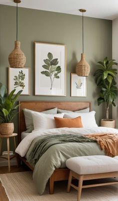 a bed sitting in a bedroom next to two plant filled wall mounted pictures on the wall