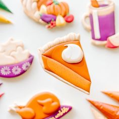 there are many decorated cookies that look like pies and carrots on the table