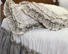 an old fashioned bed with ruffled sheets and pillows