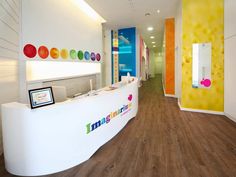 the interior of a children's hospital with brightly colored walls and wood flooring