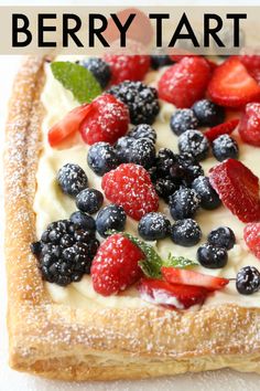 berry tart with powdered sugar on top and fresh berries in the middle for topping