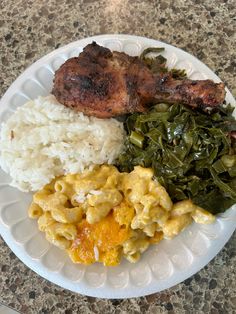 a white plate topped with meat, rice and greens