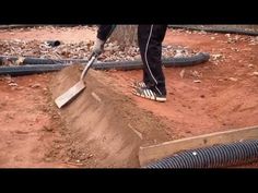 a person is shoveling dirt on the ground with a large pipe in front of them