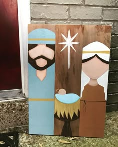 three wooden nativity boards are sitting on the ground