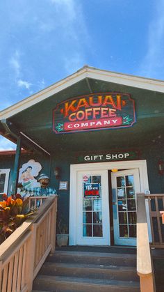 the front entrance to kauai coffee company with stairs leading up to it's door