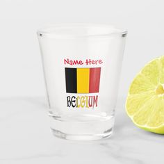 a shot glass with the name here on it next to a slice of lime and a lemon