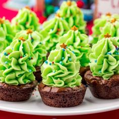 cupcakes with green frosting and sprinkles on a plate