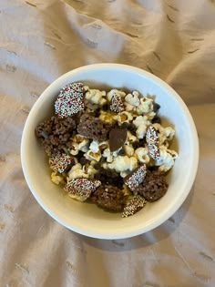 a bowl filled with chocolate and sprinkles on top of a white table cloth