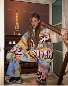 a woman sitting on top of a chair in front of the eiffel tower