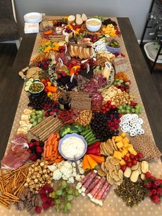 a long table covered in lots of different types of food and snacks on it's sides