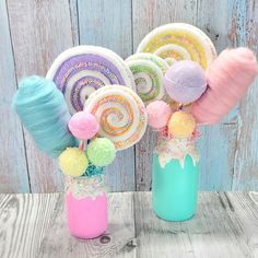 some lollipops are in a vase on a wooden table with other items