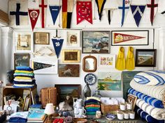 a room filled with lots of different items and pictures on the wall above it is an assortment of flags