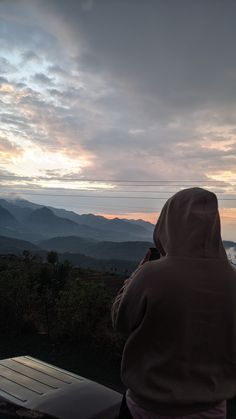 a person sitting on a bench looking at the mountains