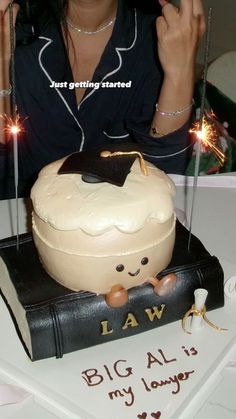 a woman sitting in front of a cake with sparklers