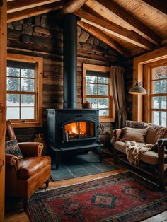 a wood burning stove in a log cabin with leather chairs and rugs on the floor