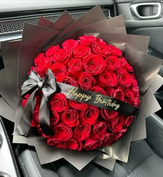 a large bouquet of red roses in the center of a car's steering wheel