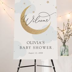 a welcome sign with a baby's name on it in front of some lights