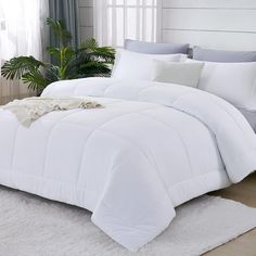 a white comforter is on the floor in front of a window