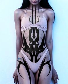 a woman in a bodysuit with black and white designs on her body is posing for the camera