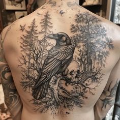 a man's back with a bird and skull tattoo on it