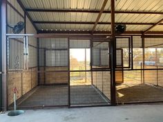 the inside of an enclosed area with metal bars and doors that are open to let in lots of light