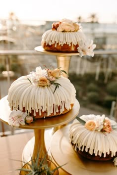 three tiered cakes with icing and flowers on them sitting on top of each other