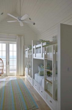 a bedroom with bunk beds and a hammock hanging from the ceiling in front of a sliding glass door