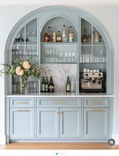 a blue bar with lots of bottles and glasses on the top shelf next to it