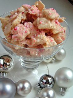 a glass bowl filled with food next to silver ornaments