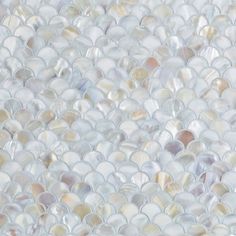 a close up view of the white and beige mosaic tile on the wall in an area that looks like it has been made out of shells