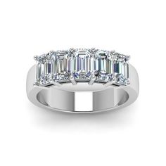 a white gold ring with three emerald cut diamonds on the side and four baguettes in