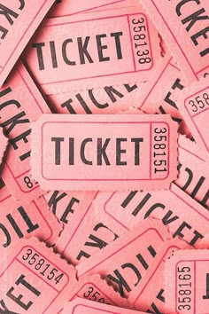 pink tickets with black and white lettering are scattered on top of each other in rows