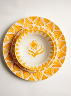 two yellow and white plates sitting on top of each other