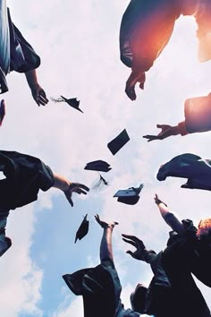 a group of graduates throwing their caps in the air