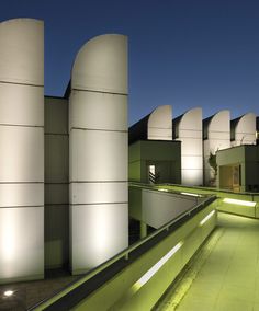 the building is lit up at night with bright lights on it's exterior walls