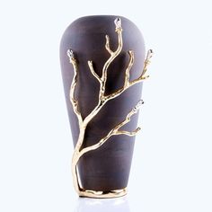 a brown vase with a gold tree on it's front and bottom, against a white background