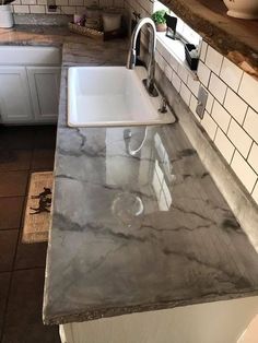 a kitchen with marble counter tops and white cabinets