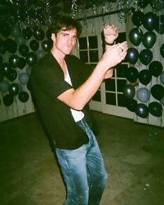 a young man is standing in front of balloons