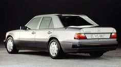 a silver mercedes benz parked in front of a black background