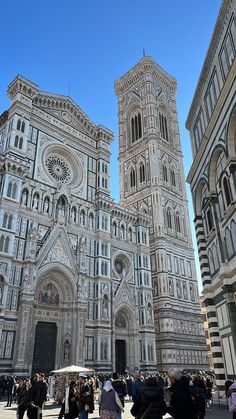 several people are standing in front of the cathedral