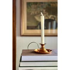 a lit candle sitting on top of a stack of books